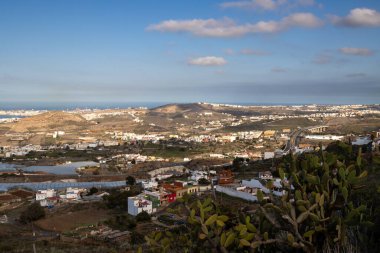 Adanın kuzeyinde bir dağdan (La Montana de Arucas) manzara. Evler ve tepeler. Beyaz bulutlu mavi gökyüzü. Arucas, Las Palmas, Gran Canaria, Kanarya Adaları, İspanya.