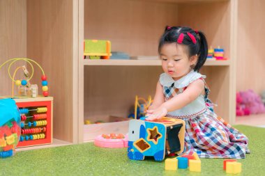 Anaokulunda Asyalı kız eğitim oyuncağı oynuyor. Geliştirme chlidhood.