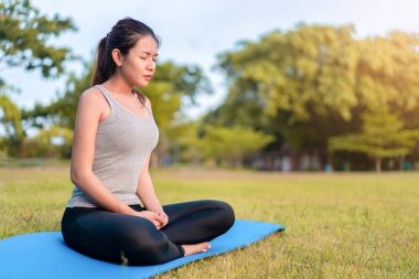 Genç Asyalı Kadın Doğa Arkaplanlı Barışçıl Açık Hava Ayarlarında Yoga Mattı Üzerinde Meditasyon Yapıyor