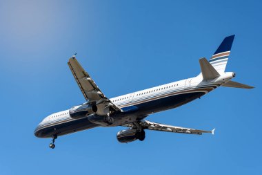 Güneşli bir günde, bulutsuz gökyüzünün altında mavi çizgileri olan modern beyaz uçaklardan.