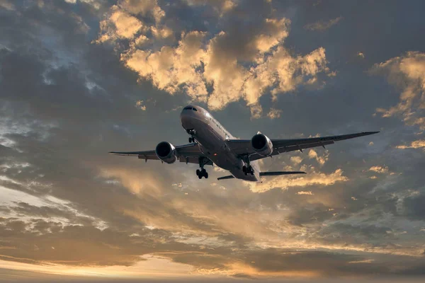 stock image horizontal image with copy space of a plane landing full of passengers against the blue sky at a beautiful sunrise