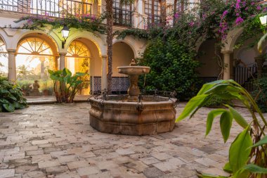 Otelin asfaltlı avlusunda yer alan eski çeşme yaz akşamları tatil köyünde yemyeşil bitkilerle doludur.