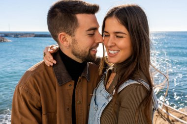 young lovers embracing celebrate valentines day in front of a seascape during a sunny day