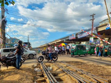 Dhaka, Bangladeş - 09.18.2022: Yoğun bir günün ortasında Khilkhet, Dhaka, Bangladeş 'te tren geçtikten sonra demiryolu hattını geçenler.