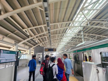 Mirpur 10, Dhaka, Bangladeş - 03.13.2023: İnsanlar sabah Dhaka Mirpur 10 istasyonundan demiryoluna çıkıyorlar. Bangladeş 'te metroya binen insanlar.