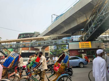 Mirpur, Dhaka, Bangladeş - 03.20.2023: Mirpur Yolu, Dhaka 'da işlek sokaklar ve trafik. Rickshaw 'lar ve insanlar metro yolunun altından geçiyorlar..