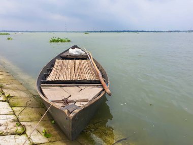 Bangladeş 'te bir nehir kıyısında, Arkaplanda Meghna Nehri olan boş bir tekne. Güney Asya 'da geleneksel boş tekne