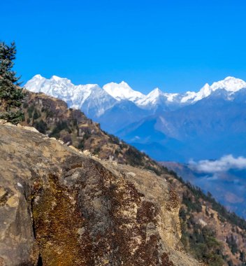 Nepal 'in Kalinchowk şehrinde, arka planda karla kaplı dağları gören dağ kayalarını kapatın..