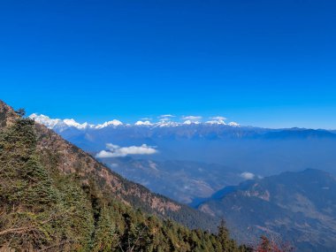 Himalayalar 'ın kar kaplı dağlarının manzarası Nepal' in Kalinchowk bölgesinden, tepeler ve bulutlarla çevrili..