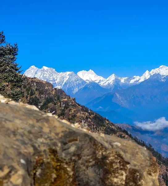 雪の景色を望む山の岩の近くには ネパールのカリンホークの背景に山をかぶった — ストック写真