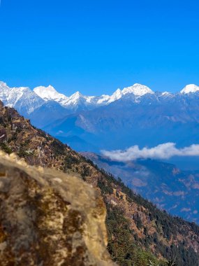 Himalayalar 'ın kar kaplı dağlarının manzarası Nepal' in Kalinchowk bölgesinden, tepeler ve bulutlarla çevrili..