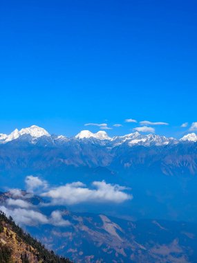 Himalayalar 'ın kar kaplı dağlarının manzarası Nepal' in Kalinchowk bölgesinden, tepeler ve bulutlarla çevrili..