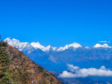 Himalayalar 'ın kar kaplı dağlarının manzarası Nepal' in Kalinchowk bölgesinden, tepeler ve bulutlarla çevrili..