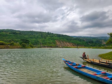 Niladri Gölü, Sunamganj, Bangladeş - 13.08.2023: Hindistan Bangladeş sınırı yakınlarında kara bulutlu Niladri Gölü 'nde tekneleriyle bekleyen insanlar. Güzel Bangladeş
