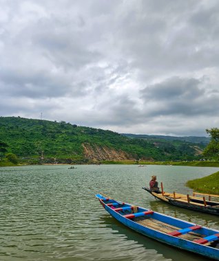Niladri Gölü, Sunamganj, Bangladeş - 13.08.2023: Hindistan Bangladeş sınırı yakınlarında kara bulutlu Niladri Gölü 'nde tekneleriyle bekleyen insanlar. Güzel Bangladeş