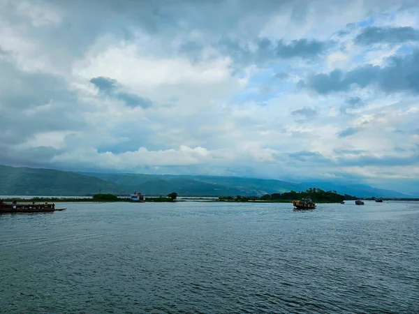 Tanguar Haor Houseboat yağmur mevsiminde Bangladeş 'in Hindistan sınırı yakınlarındaki nehirde yol alıyor. Arka planda güzel Meghalayan tepeleri var..