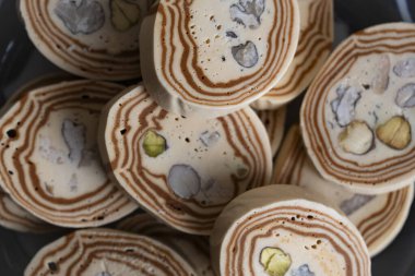 Özbek seramik tabakasında servis edilen kremalı şam fıstığı halkası, katmanlı dokusunu ve Orta Asya kültür mirasını ön plana çıkarıyor.