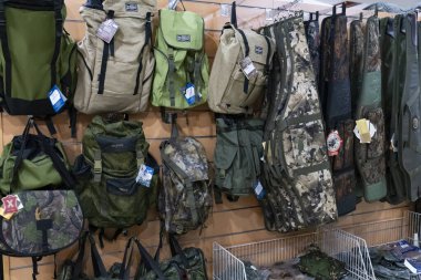 Taşkent, Özbekistan, 26 Temmuz 2025: Bir mağazada yürüyüş, avcılık ve askeri temalar için ideal olan taktik sırt çantaları, kamuflaj tüfek kılıfları ve açık hava teçhizatları sergileniyor