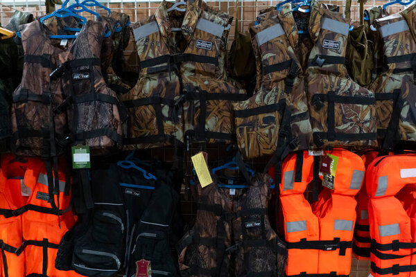 Tashkent, Uzbekistan, July 26, 2025: Assortment of military and outdoor clothing on hangers in a store. Camouflage, jackets, sweaters, and uniforms for tactical, hunting, and outdoor activities