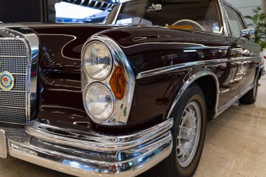 Taşkent, Özbekistan, 18 Ağustos 2025: Klasik kestane rengi Mercedes-Benz, krom detaylar, çift farlar ve ikonik ızgara, kapalı alanda parlak kaplama ve zarif bir stile sahip.