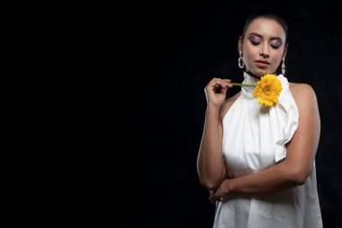 Beyaz tişörtlü, beyaz elbiseli, sarı çiçekli güzel bir kızılderili kadın mankeni.