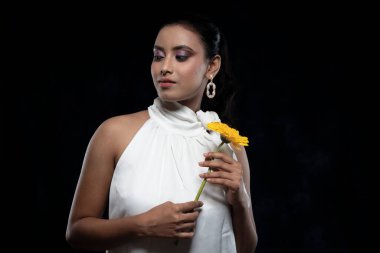 Beyaz tişörtlü, beyaz elbiseli, sarı çiçekli güzel bir kızılderili kadın mankeni.