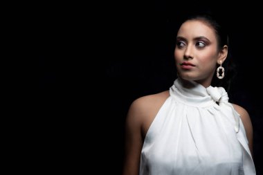 Beyaz tişörtlü beyaz elbiseli güzel bir Hintli kadın mankenin tekli görüntüsü.