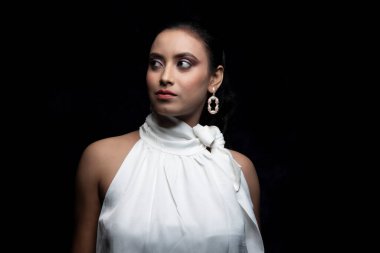 Beyaz tişörtlü beyaz elbiseli güzel bir Hintli kadın mankenin tekli görüntüsü.
