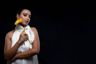 Beyaz tişörtlü, beyaz elbiseli, sarı çiçekli güzel bir kızılderili kadın mankeni.