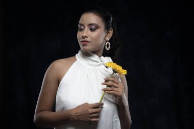 Beyaz tişörtlü, beyaz elbiseli, sarı çiçekli güzel bir kızılderili kadın mankeni.