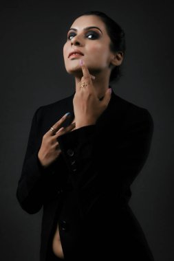 Klasik siyah takım elbiseli uzun boylu bir kadın modelin çarpıcı bir solo görüntüsü. Gösterişli çizgiler ve cilalı görünüş, resmi monokrom giyiminin zarafetini, güzelliğini ve çok yönlülüğünü vurguluyor. Uzun ve çarpıcı bir kadın modeli şık bir siyah takım elbise içinde poz veriyor. Şey...