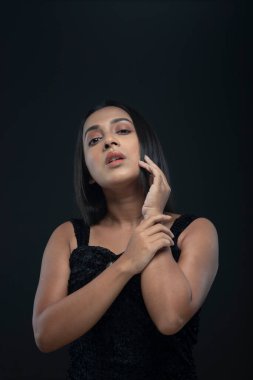 Uzun siyah saçlı, açık tenli, siyah etekli, yalnız bir manken.