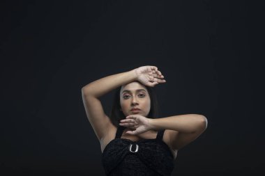 Uzun siyah saçlı, açık tenli, siyah etekli, yalnız bir manken.