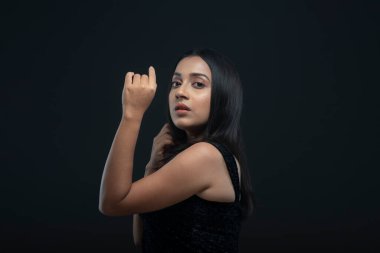 Uzun siyah saçlı, açık tenli, siyah etekli, yalnız bir manken.