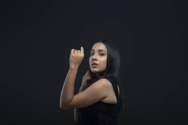 Uzun siyah saçlı, açık tenli, siyah etekli, yalnız bir manken.