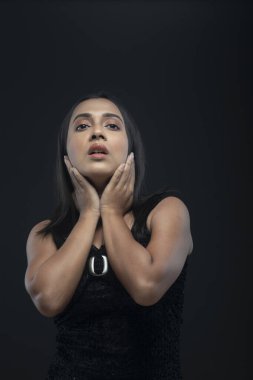 Siyah etek giyen, uzun siyah saçlı, yalnız bir kadın manken.