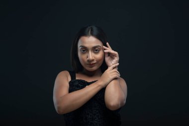 Siyah etek giyen, uzun siyah saçlı, yalnız bir kadın manken.