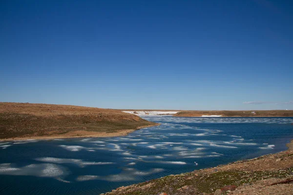 stock image Arctic landscape in summer time. A river with broken ice flowing along a barren tundra. Near Cambridge Bay, Nunavut, Canada