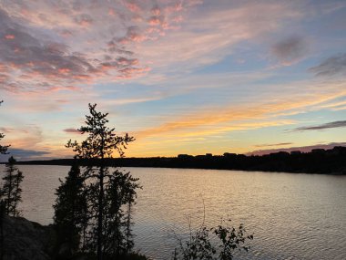 Kuzey Kutbu ağaçlarının üzerinde güzel bir günbatımı ve Yellowknife yakınlarında bir göl, Kuzeybatı Toprakları, Kanada