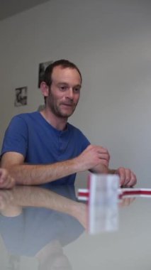 Kafkasyalı genç adam, iç kısımda güverteye domino taşı koyuyor. İnsanlar aile ve arkadaşlarıyla eğlenmek için Domino oynar. Yüksek kaliteli görüntüler