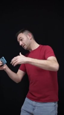 Milli takım taraftarı kırmızı t-shirt giyip cep telefonuyla Dünya Kupası maçını izliyor ve golü yumrukla kutluyor. 2022 Katar konseptini kopyala. Yüksek kalite fotoğraf