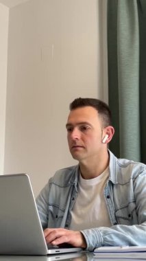 Endişeli Adam evden çalışıyor. Alnına yumruk indiriyor ve ne felaket diyor. Dikey 4K beyaz. Yüksek kaliteli FullHD görüntüler