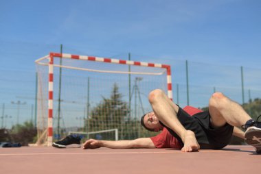 Orta yaşlı bir adam futbol sahasında yaralı bacağı, şişmiş eklemleri ile yatıyor, karşılıklı kaza sigorta şirketine ihtiyacı var, spor risk kavramını oynayan formda insanlara değil. Yüksek kalite fotoğraf