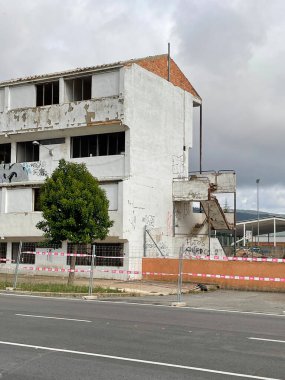 Ibi, İspanya - 22 Mayıs 2023. Kasaba öğretmenlerinin terk edilmiş eski evleri yıkıma hazır. Bulanık gün, dikey fotoğraf