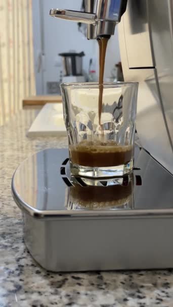 コーヒーマシンでコーヒーエスプレッソやレストレットを作る ホットエスプレッソを作るホーム 凍ったコーヒー 透明なカップに入ったエスプレッソ 美味しいコーヒー カフェイン 高品質のフルHd映像 — ストック動画