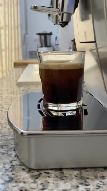 在咖啡机里喝咖啡 浓缩咖啡或伸缩咖啡 在家做热咖啡 一杯透明杯子里有泡沫的咖啡 味道很好的咖啡咖啡因 高质量的4K镜头 — 图库视频影像