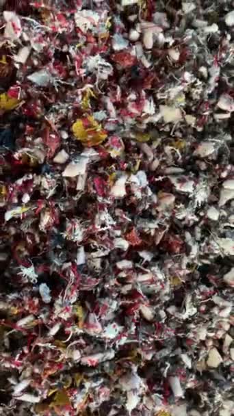 リサイクルされた織物 ゴムまたはペーパーの小さい部分は製造所を粉砕するためにリサイクルプロセスで動きます 循環型経済 再利用 リサイクル 地球デイコンセプト スローモーション 垂直パンニング — ストック動画
