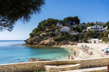 14 Nisan 2024, Cala Fustera Sahili, Alicante, İspanya. Hava aracı görüntüsü, ekolojik yürüyüş Benissa Calp, yaya yolu, blog veya seyahat rehberi görüntüsü. Turistlerle dolu berrak bir su.