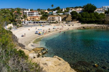 14 Nisan 2024, Cala Fustera Sahili, Alicante, İspanya. Hava aracı görüntüsü, ekolojik yürüyüş Benissa Calp, yaya yolu, blog veya seyahat rehberi görüntüsü. Turistlerle dolu berrak bir su.