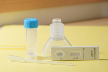 COVID tükürük testi sarı arka planda kopyalama alanı ile izole edildi. Yüksek kalite fotoğraf